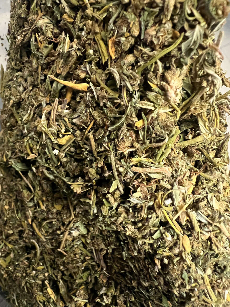 Close-up of finely trimmed Delta 8 Sour Lifter cannabis shake showcasing rich green hues.