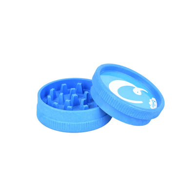 Blue Cookies plastic grinder with open lid showing grinding teeth and wave logo design.