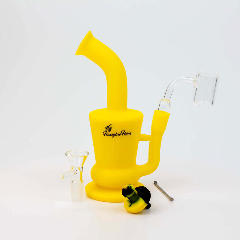 Silicone travel bong rig with honeycomb design, 14mm female joint, quartz nail, glass flower bowl, and metal dab tool from Honeybee Herb