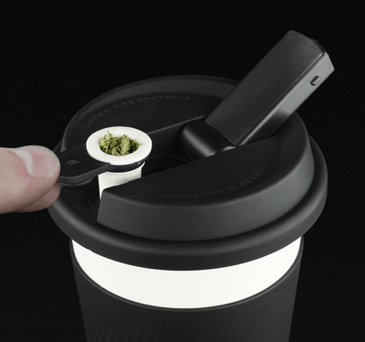 Puffco Cupsy black coffee cup water pipe with hidden herb bowl storage in use for discreet smoking.